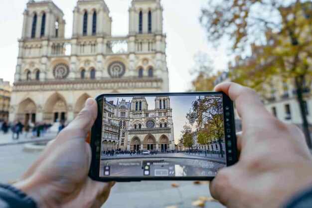 a person is holding a phone with a picture of a cathedral in the background