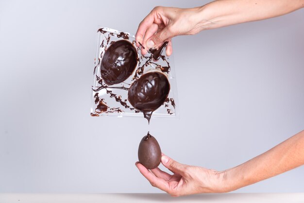 a person is pouring chocolate sauce over a spoon with chocolate covered strawberries