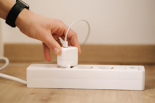 A person is pulling a plug in a power strip.