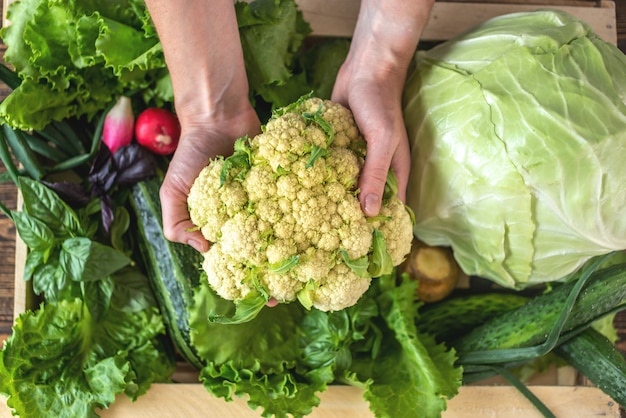 Person is taking fresh vegetables out of a wooden box