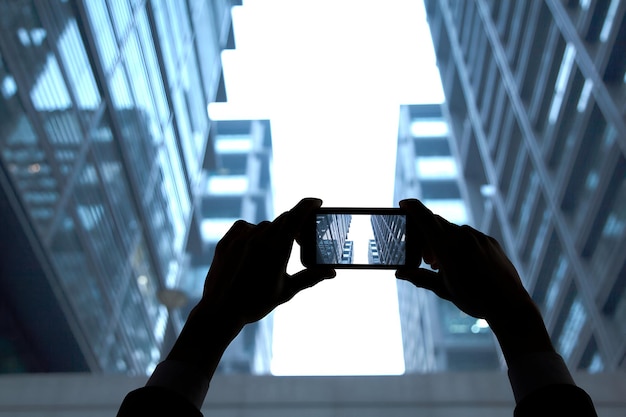 Photo a person is taking a picture of a building with a phone that sayshoon it