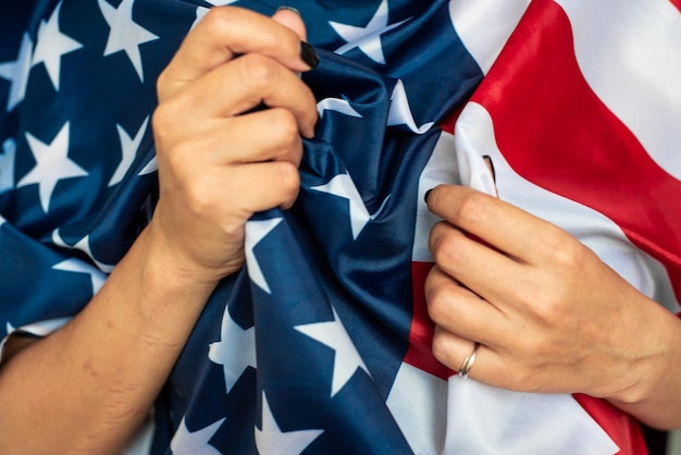 A person is tying the stars on a american flag.