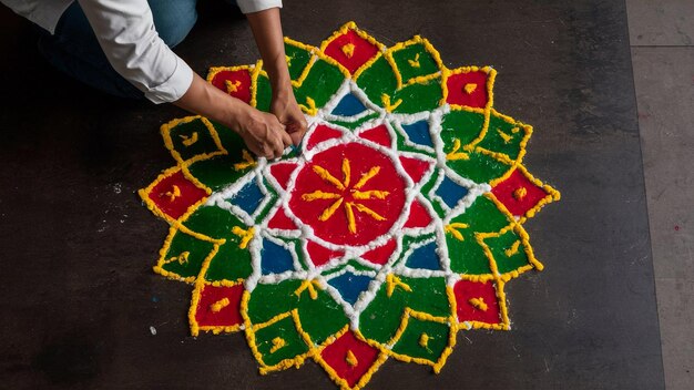 Photo a person is writing on a flower design on a black surface