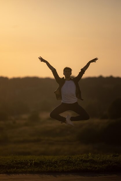 A person jumping in the air with the sun setting behind them