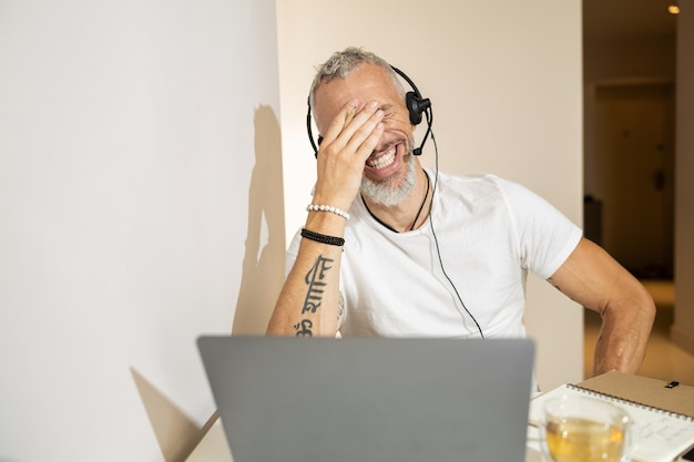 Person laughing to tears on something funny at video meeting