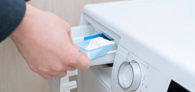 Person load the washing powder detergent in the machine