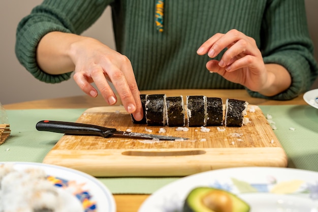 Person making delicious homemade sushi in the kitchen