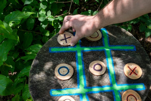 person playing tic tac toe made out of wood. Environmental natural games