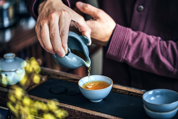 A person pouring a cup of coffee into a cup.