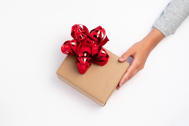 Person receiving christmas gift with a red ribbon