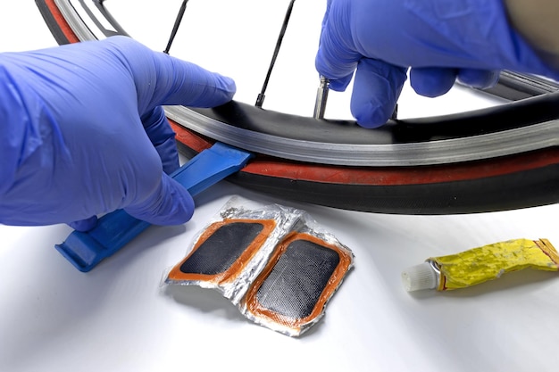 A person repairs a puncture of a bicycle wheel using cycling repair tools photo on white background 2