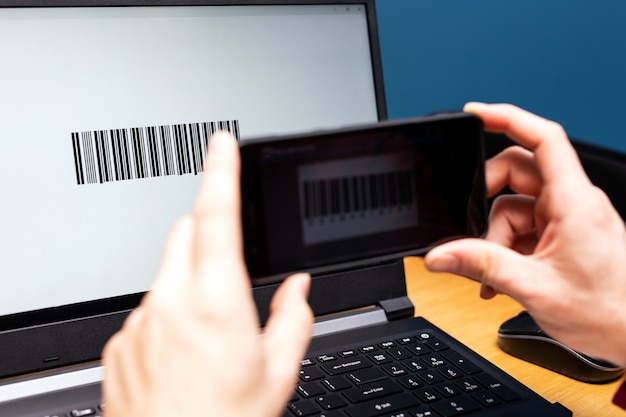 Person scanning with mobile phone, barcode on a computer screen, online modern payment with scanning app smartphone