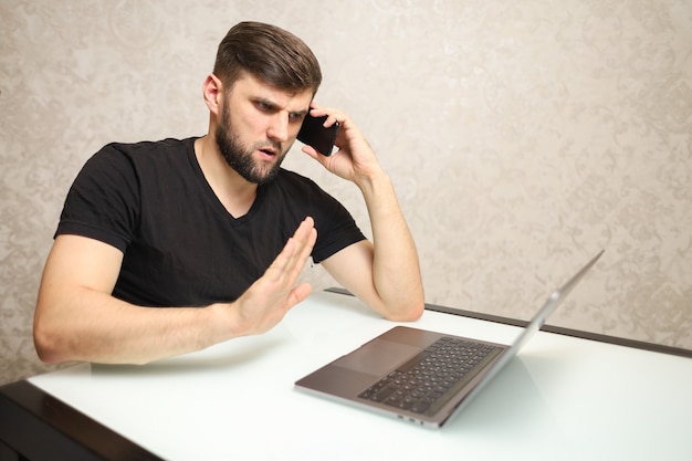 a person in self isolation works at home on a laptop talking on the phone