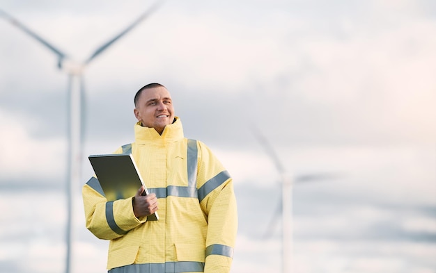 Person standing next to wind turbine