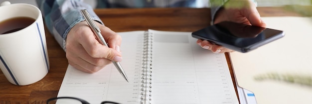 Person start day right with planner and cup of coffee make appointment plan