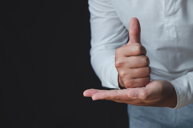 Person that wear white shirt shows thumbs up sign Salaryman or business man Like or good concept Close up shot with copy space