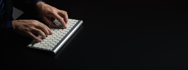 Person typing on a computer keyboard businessman is working in a startup company's office he is typing messages to his colleagues and making financial documents summarizing the meetings Copy space