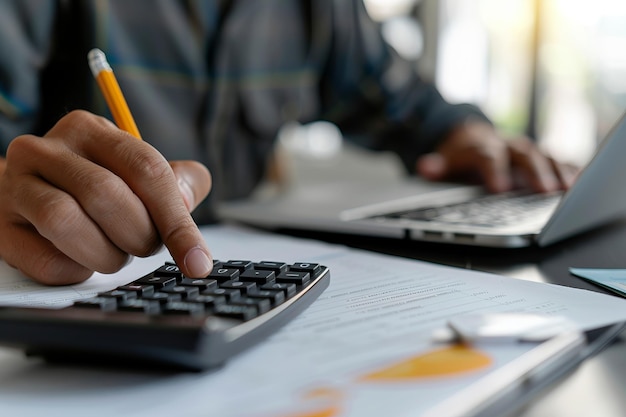 Person using calculator and working on laptop at desk Close up of hand with pencil on calculator Office environment and casual work attire Concept of workplace productivity Generative AI