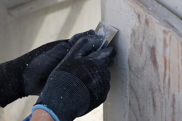 Photo a person using a trowel to cut a concrete slab.