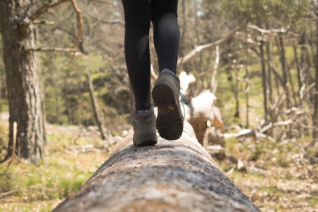 Person walking through the forest in nature closeup of the boots