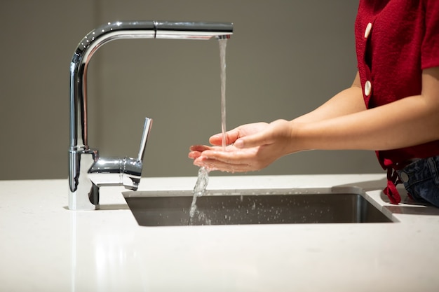 Person washing hands in kitchen