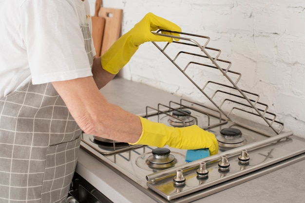 Person washing the stove with gloves