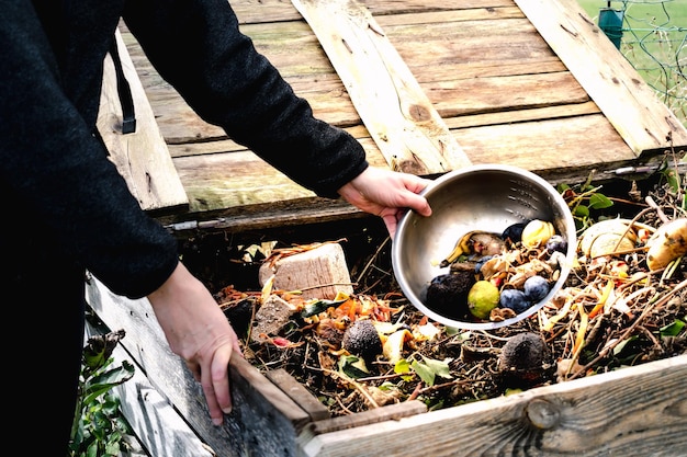 Person who put in a composter some kitchen waste like vegetables fruits eggshell coffee grounds in order to sort and make bio fertilizer