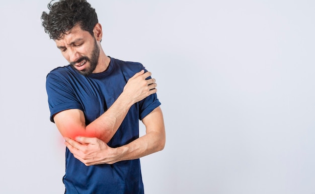 Person with elbow pain concept of a man with rheumatism elbow pain man massaging sore elbow man with elbow cramp