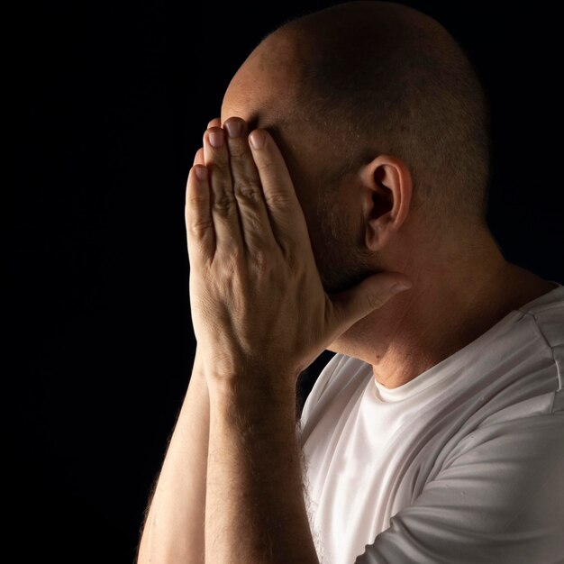 Person with hands on face against dark background Salvador Bahia Brazil