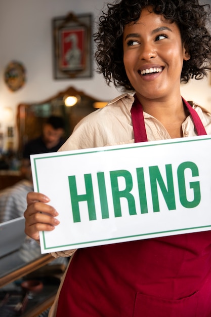 Person with hiring sign by the window