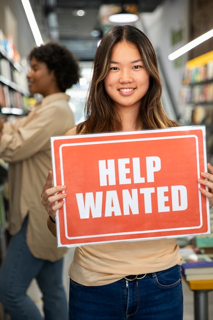 Person with hiring sign by the window