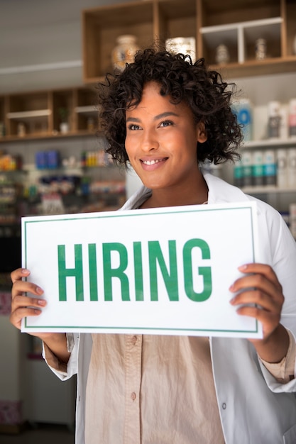 Person with hiring sign by the window