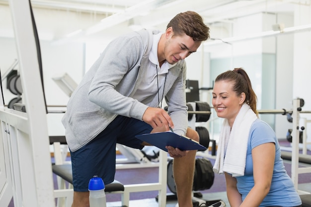 Personal trainer and client looking at clipboard together