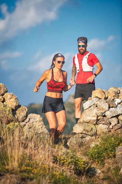 A personal trainer takes his client for a run in the hills