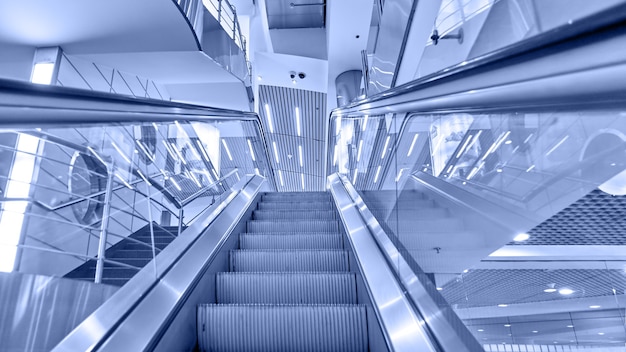 Perspective of escalator toned in blue color