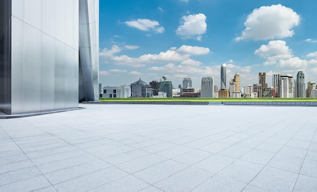 Perspective view of empty concrete tiles floor with city skyline