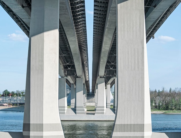 Perspective view of support pillars of bridge or highway through river Industrial background