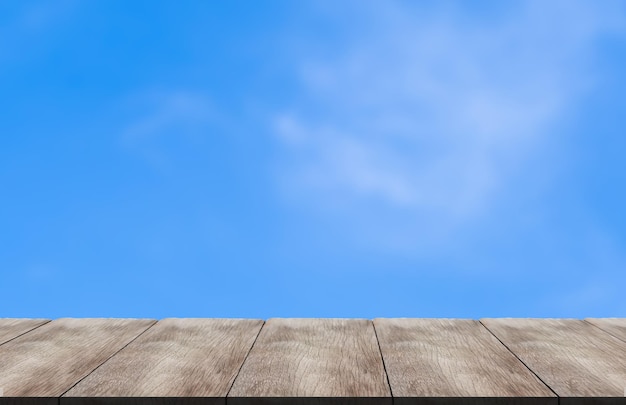 Perspective wooden table. Bright sky background and few clouds and faint