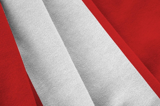 Peru flag with big folds waving close up under the studio light indoors the official symbols and col