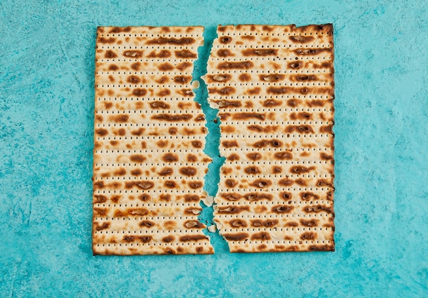 Pesach celebration concept Jewish holiday Pesach Matzah square broken in half View from above Flat lay