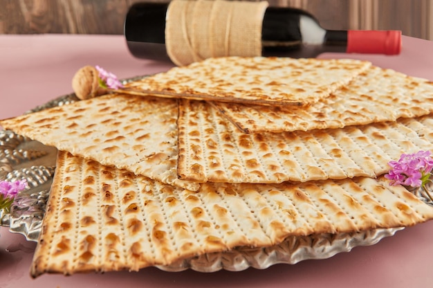 Pesach celebration concept  jewish Passover holiday Matzah on Seder plate with bottle of red wine and nuts