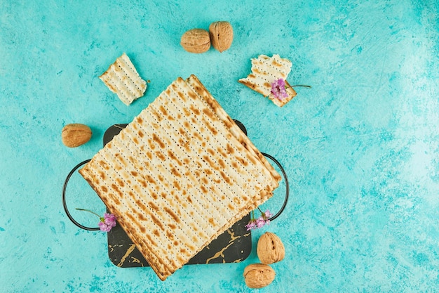 Pesach celebration concept  jewish Passover holiday Matzah on stand made of marble with walnuts and wildflowers