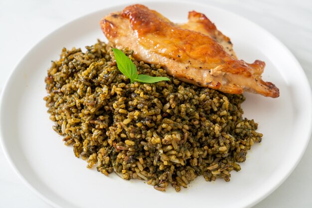 pesto fried rice with grilled chicken on white plate