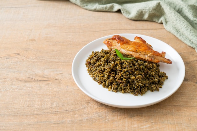 pesto fried rice with grilled chicken on white plate