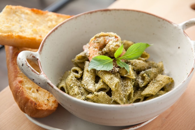 Pesto penne pasta with shrimp and garlic bread