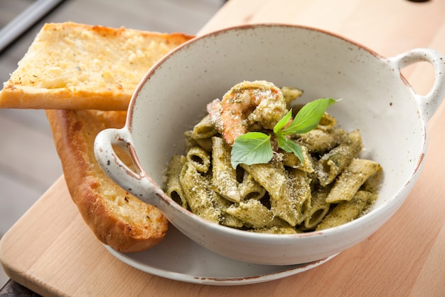 Pesto penne pasta with shrimp and garlic bread