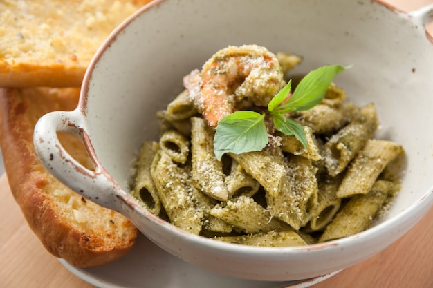 Pesto penne pasta with shrimp and garlic bread