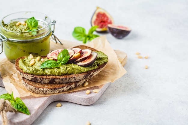 Pesto sauce sandwich with figs on rye bread.