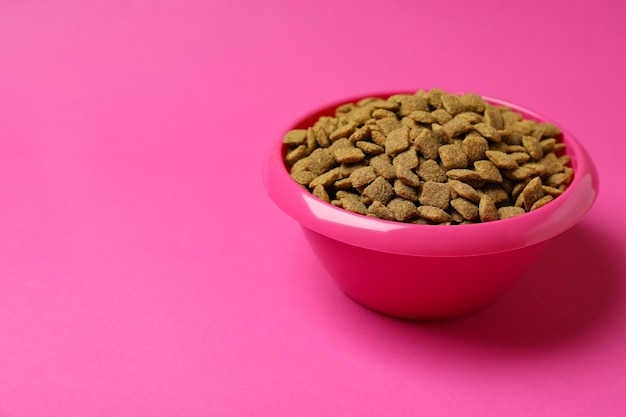 Pet bowl with feed on pink