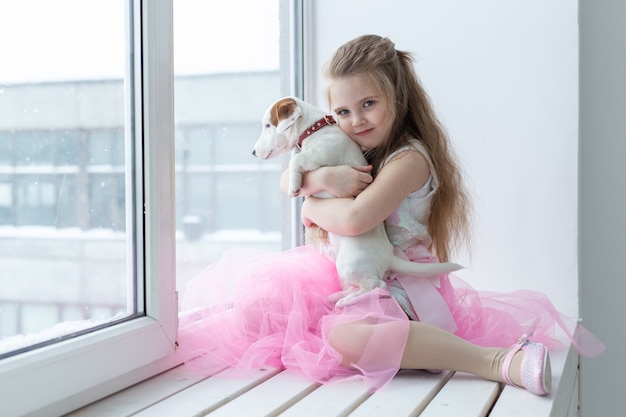 Pet and children concept - Child with dog Jack Russell Terrier at home.